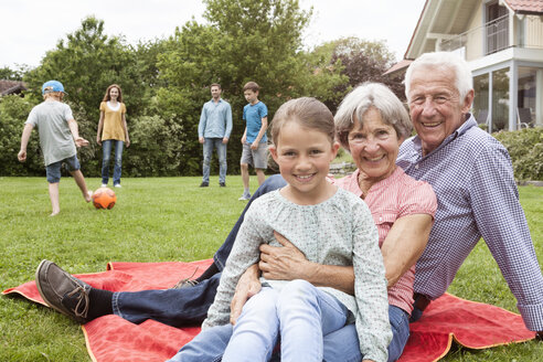 Porträt einer glücklichen Großfamilie im Garten - RBF004765