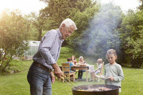 Grandfather and granddaughter on a family barbecue stock photo