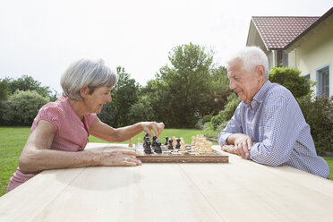 Älteres Paar spielt Schach im Garten - RBF004807