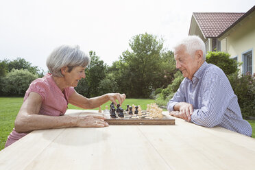 Senior couple playing chess in garden - RBF004807