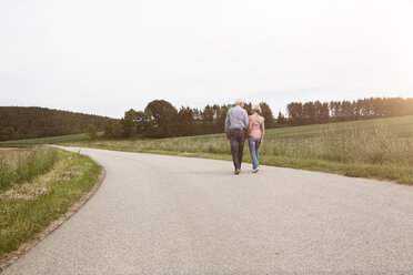 Älteres Paar beim Spaziergang auf der Landstraße - RBF004818