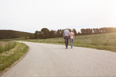 Senior couple walking on country road - RBF004818