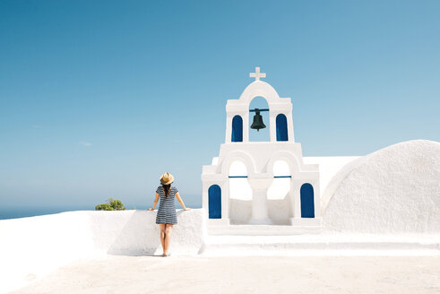 Griechenland, Santorini, Oia, Rückenansicht einer Frau, die neben dem Glockenturm steht und auf das Meer blickt - GEMF000930