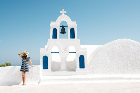 Griechenland, Santorini, Oia, Rückenansicht einer Frau, die neben dem Glockenturm steht und auf das Meer blickt - GEMF000931