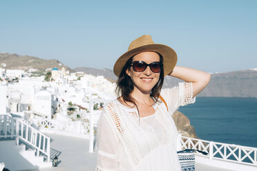 Griechenland, Santorin, Oia, Porträt einer lächelnden Frau mit Sonnenbrille und Strohhut - GEMF000933