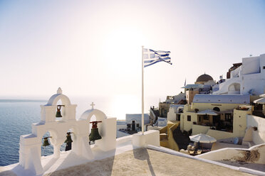 Griechenland, Santorini, Oia, griechische Flagge weht auf einer Kirche bei Sonnenuntergang - GEMF000934