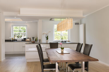 Modern dining area with open plan kitchen in the background - SHKF000632