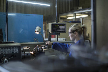 Female mechanic working on machine in workshop - ZEF009310