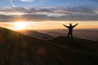 Italy, Umbria, Monte Acuto, Sunset over Umbrian Apennines, hiker with raising arms - LOMF000315