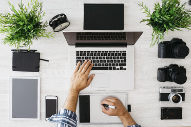 Photographer working at desk with laptop, top view - JRFF000772