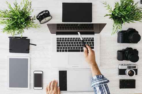 Fotograf bei der Arbeit am Schreibtisch mit Laptop, Draufsicht - JRFF000773