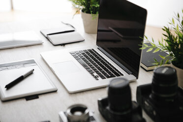 Desk of photographer with laptop, cameras, tablet and graphics tablet - JRFF000779