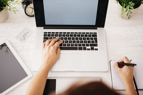 Frau arbeitet am Schreibtisch mit Laptop, Draufsicht - JRFF000788