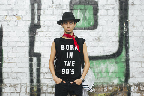 Modischer junger Mann mit Hut und T-Shirt mit der Aufschrift 'Born in the 90s', lizenzfreies Stockfoto