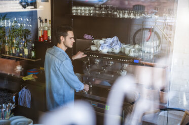 Junger Mann bereitet Kaffee in einem Café zu - DIGF000782