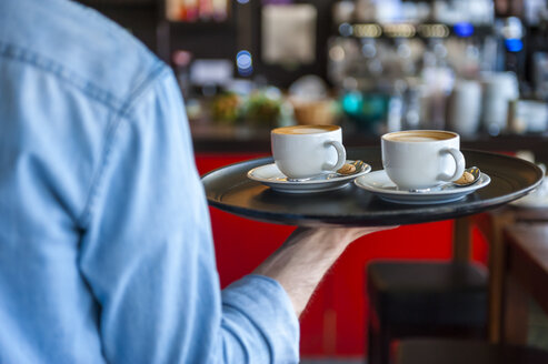 Kellner trägt Tablett mit Cappuccinotassen in einem Café - DIGF000798