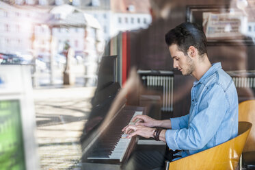 Young man playing piano in a cafe - DIGF000801
