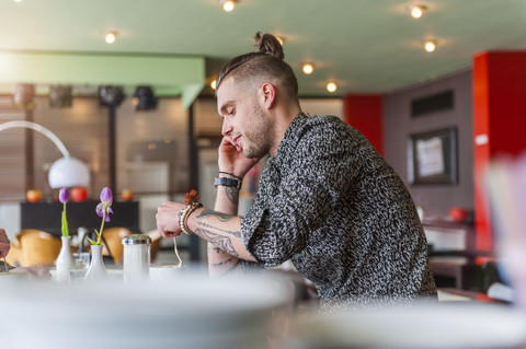 Stilvoller junger Mann in einem Cafe, lizenzfreies Stockfoto