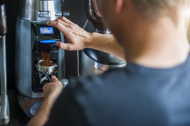 Mann bereitet Kaffee an einer Kaffeemaschine zu - DIGF000811