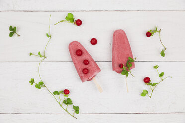 Two homemade wild strawberry ice lollies on wood - GWF004857