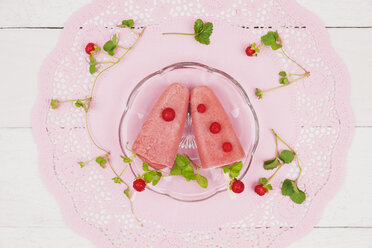 Hausgemachte Walderdbeereislutscher auf Glasteller und rosa Tortenspitze - GWF004860