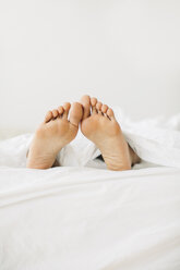 Feet of woman lying in bed - EBSF001547