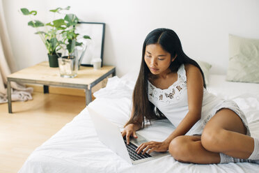 Junge Frau im Bett liegend mit Laptop - EBSF001573