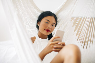 Young woman in hammock using cell phone - EBSF001587