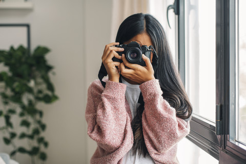 Frau fotografiert Betrachter mit Kamera, lizenzfreies Stockfoto