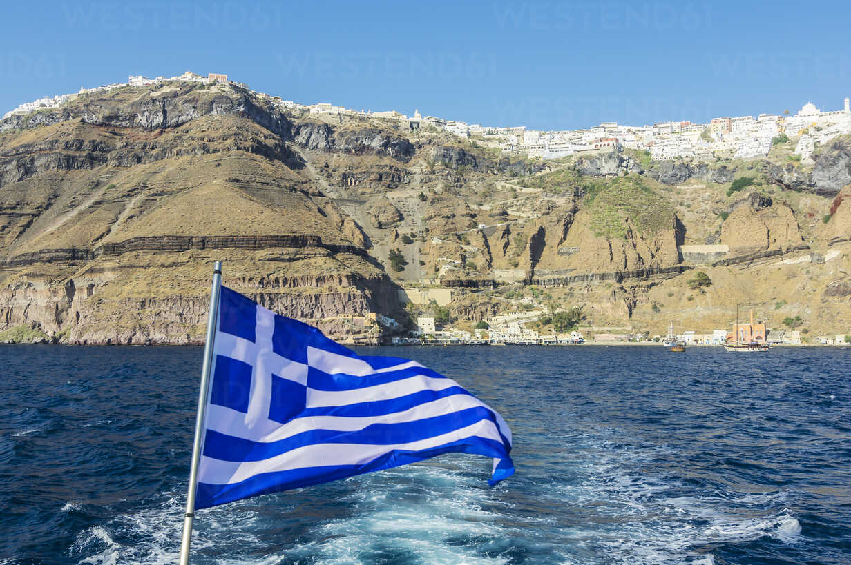 Griechenland, Santorin, griechische Flagge mit Fira im Hintergrund