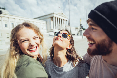 Austria, Vienna, three friends having fun in front of the parliament building - AIF000351