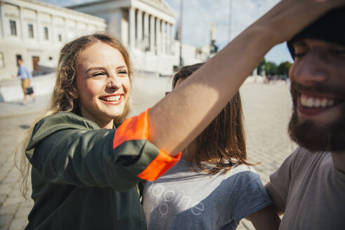 Austria, Vienna, three friends having fun in front of the parliament building - AIF000353