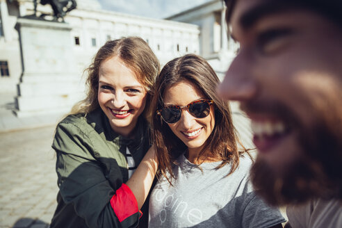 Austria, Vienna, three friends having fun in front of the parliament building - AIF000354