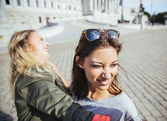 Austria, Vienna, two young women having fun in front of the parliament building - AIF000355