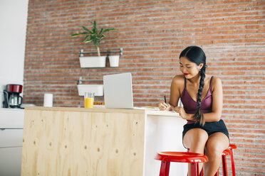 Woman working on kitchen counter at home - EBSF001662