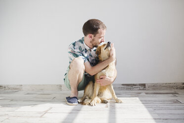Mann kuschelt mit seinem Hund - MRAF000103