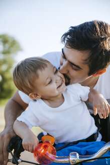 Vater küsst seinen kleinen Sohn auf Fahrradtour - ZEDF000254