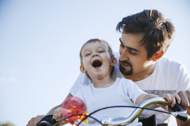 Lachender kleiner Junge auf Fahrradtour mit seinem Vater - ZEDF000256