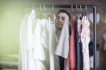 Man looking at clothes stand in boutique - ZEF009366