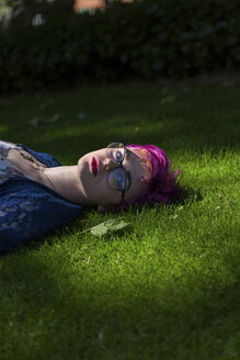 Portrait of young woman with dyed hair lying on a meadow - BOYF000465