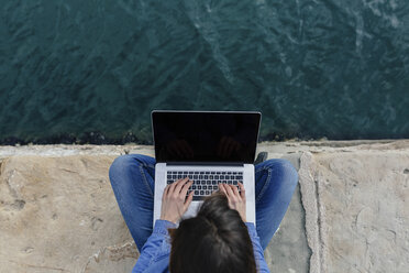 Young woman sitting on dock using laptop - BOYF000483