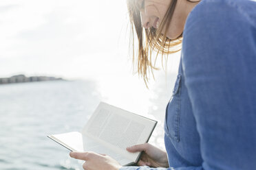 Junge Frau liest ein Buch am Wasser - BOYF000491