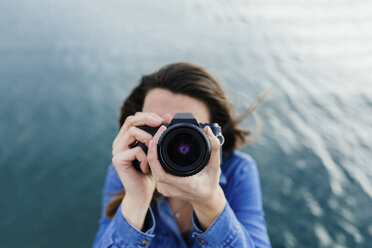 Junge Frau am Wasser beim Fotografieren - BOYF000497