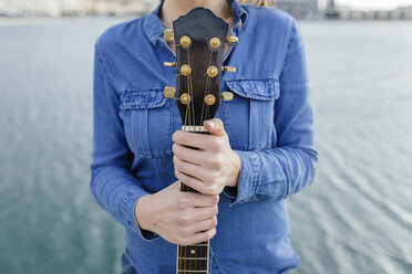 Young woman at the waterfront holding guitar - BOYF000502