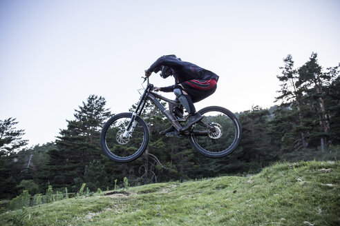 Mountainbiker fährt bergab und springt in der Luft - ABZF000897