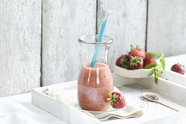 Glass bottle of strawberry smoothie with chia and strawberries - ASF005957