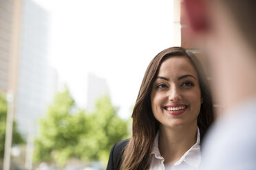 Smiling young woman looking at man - FKF002001