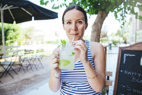 Happy woman drinking homemade lemonade in summer - GEMF000944