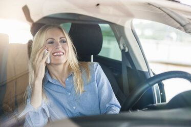 Lächelnde Frau im Auto beim Telefonieren - DIGF000831