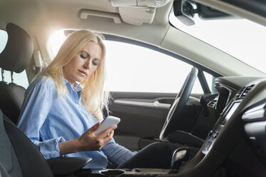 Woman in car looking on cell phone - DIGF000832